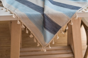Détail de nappe imperméable à rayures bleues avec texture lin en coton et glands de franges