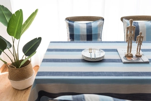 Détail de la nappe imperméable rayée bleue et blanche avec son ensemble de coussins