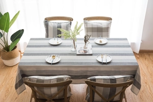 Detail of gray and cream striped waterproof tablecloth in a bright nordic style dining room