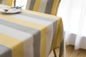 Close-up of waterproof striped tablecloth featuring yellow and grey linen fabric texture