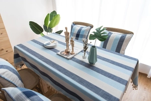 Détail de la nappe imperméable à rayures bleues avec glands et coussins assortis