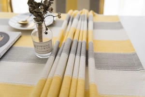 Close-up of woven cotton linen table runner with modern yellow and grey stripes texture