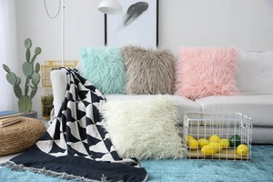 Detailed texture of fluffy faux fur decorative cushions in soft pastel colors on a sofa