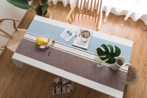 Detail of Nordic patchwork tablecloth with elegant wavy lace trim and textured fabric