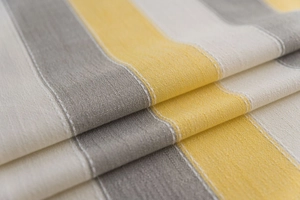 Close-up of yellow and grey striped linen texture fabric with white stitching details