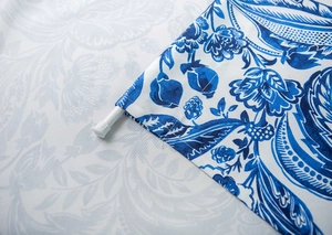 Detail of blue and white floral fabric curtain showing the rod pocket installation