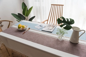 Detailed view of Nordic cotton linen tablecloth featuring blue embroidery and tassel fringe