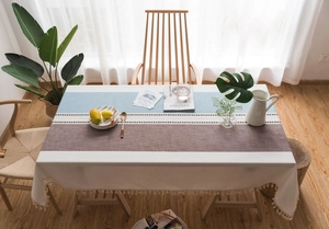 Detail of Nordic blue and coffee patchwork tablecloth with geometric patterns and tassels