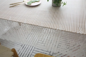 Détail de la nappe en dentelle blanche avec bordure florale et rayures en maille