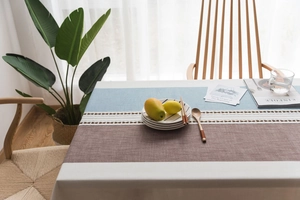 Close-up of Nordic style tablecloth featuring tricolor patchwork and wavy ribbon detail