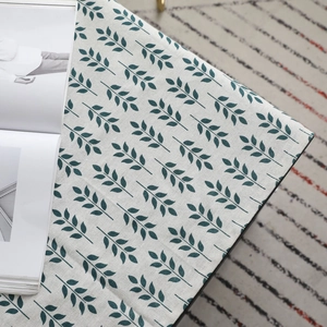 Nappe scandinave en coton et lin avec motifs de feuilles vertes sur fond beige clair