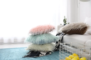 Close-up of soft faux sheepskin fur texture on decorative plush pillow covers in pastel tones