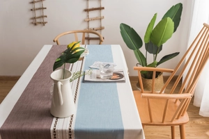 Detail of Nordic striped table runner with faux linen texture and fringe accents