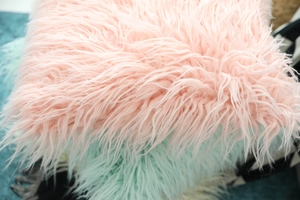 Close-up of fluffy pink faux wool pillow cover showing long plush fiber texture