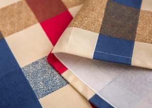 Detailed macro view of the woven fabric texture and stitching on the Nordic plaid cover cloth