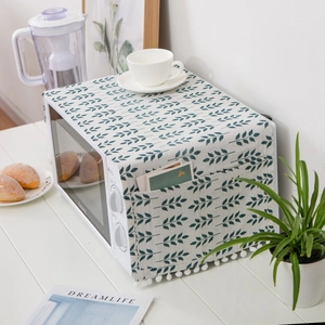 Microwave oven dust cover with green leaf print, side pockets and white pom-pom trim