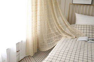 Gros plan de rideaux au crochet beige avec motifs floraux et texture translucide élégante