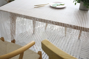 Détail de la nappe en dentelle blanche avec bords floraux et texture de maille rayée