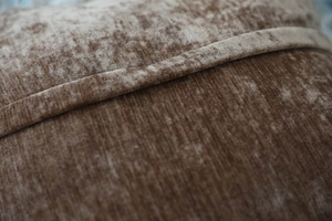 Detailed close-up showing brown velvet fabric texture and precision stitching on pillowcase