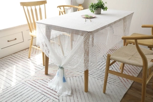 Détail d'une nappe en dentelle blanche avec bordures festonnées et motifs ajourés élégants