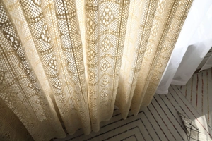 Gros plan du rideau rétro en dentelle au crochet beige aux textures florales