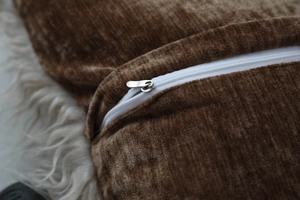 Close-up of durable zipper and texture on a brown chenille throw pillow cover