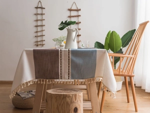 Close-up of Nordic boho tablecloth with embroidery lace and beige tassel fringes