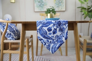 Detail shot of blue and white floral table runner on solid wood dining table