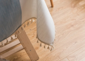 Detail of Nordic style tablecloth with beige tassels and blue patchwork fabric texture