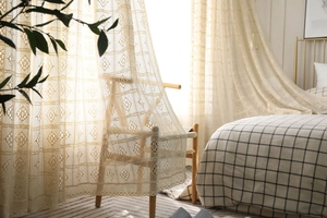Détail du rideau au crochet beige avec motifs de fleurs géométriques ajourés rétro