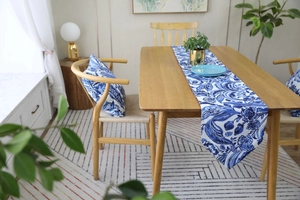 Detail of blue and white floral table runner and matching pillow in a farmhouse setting