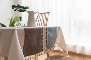 Detail of Nordic style tablecloth featuring ethnic embroidery, patchwork and lace tassels