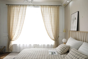 Détail du rideau en dentelle crochetée beige avec motif géométrique dans une chambre rustique
