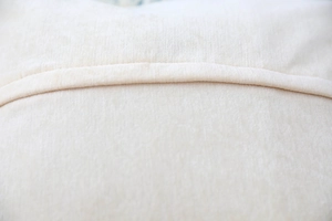 Macro view of cream faux wool pillow cover showing fine texture and durable stitching