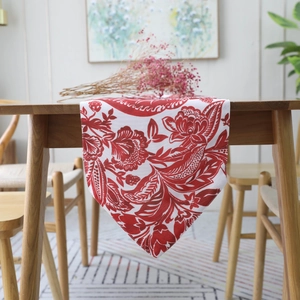 Red damascus floral table runner in farmhouse style on a rustic wooden dining table