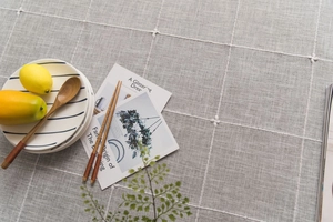 Macro detail of Nordic grey checkered linen tablecloth with embroidered floral patterns