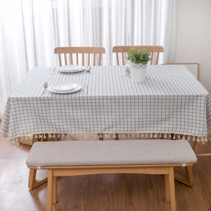 Detailed close-up of cotton linen plaid tablecloth with decorative white tassels