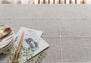 Close-up of Nordic style grey checkered cotton linen tablecloth with white floral embroidery