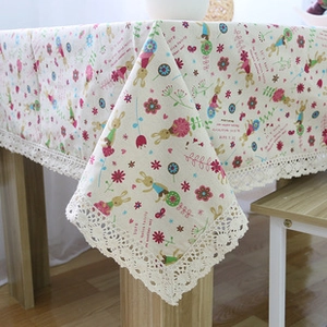 Detail van pastoraal linnen tafelkleed met konijnenprint en kanten afwerking