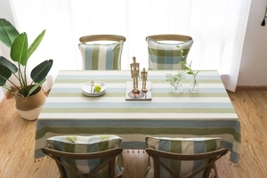 Close-up of green and beige striped waterproof tablecloth with elegant tassel edges