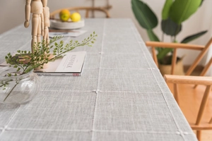 Macro detail of Nordic grey cotton linen tablecloth with white embroidery and grid pattern