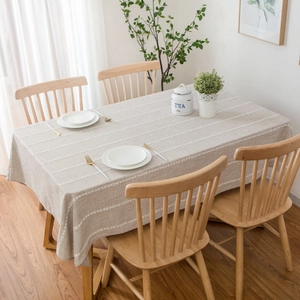 Rectangle beige linen tablecloth with white stripes on a wooden dining table
