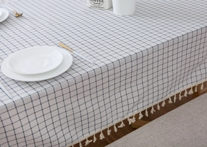 Detail of blue and white checkered cotton linen tablecloth with elegant fringe edges