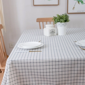 Close-up of blue and white checkered cotton linen tablecloth with elegant fringe detail
