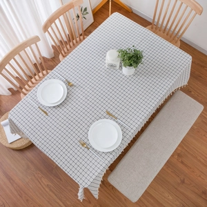 Minimalist white and black checkered cotton linen tablecloth with tassel edges on wood table
