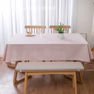 Detailopname van het roze en witte ruitpatroon en de linnen textuur van het tafelkleed op tafel
