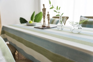 Close-up of green and blue striped linen tablecloth with neat stitching details