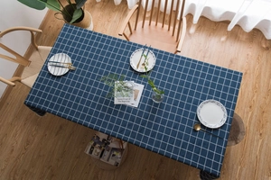Detail of dark blue checkered linen tablecloth with Nordic style dinnerware set