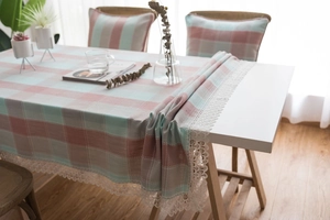 Detailed view of pink and blue plaid tablecloth with elegant white lace embroidery edges