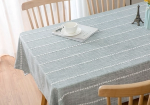 Detail of light green cotton linen tablecloth with white hollowed-out stripe patterns